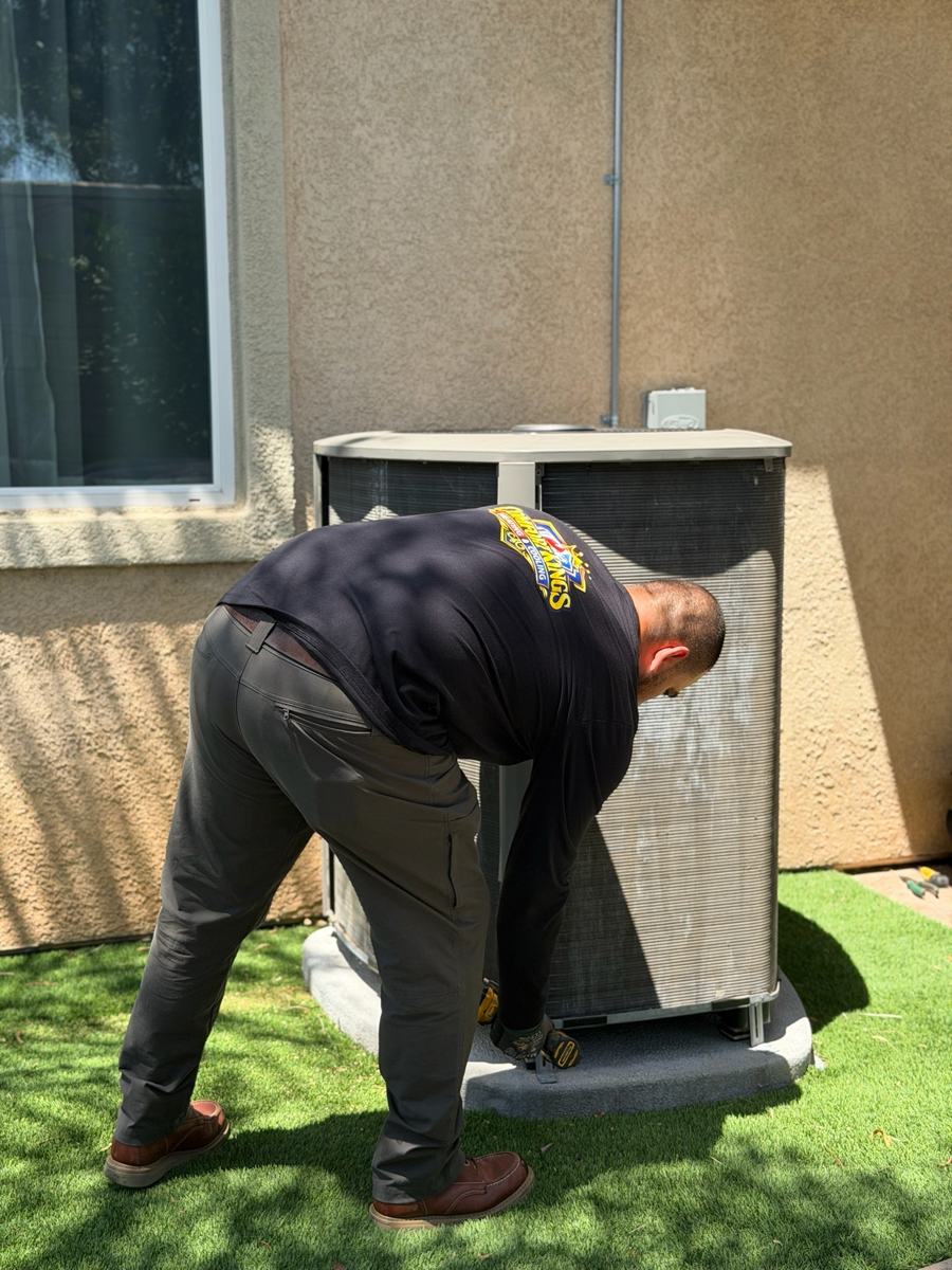 Caesar lifting the cover off a condenser during a maintenance visit