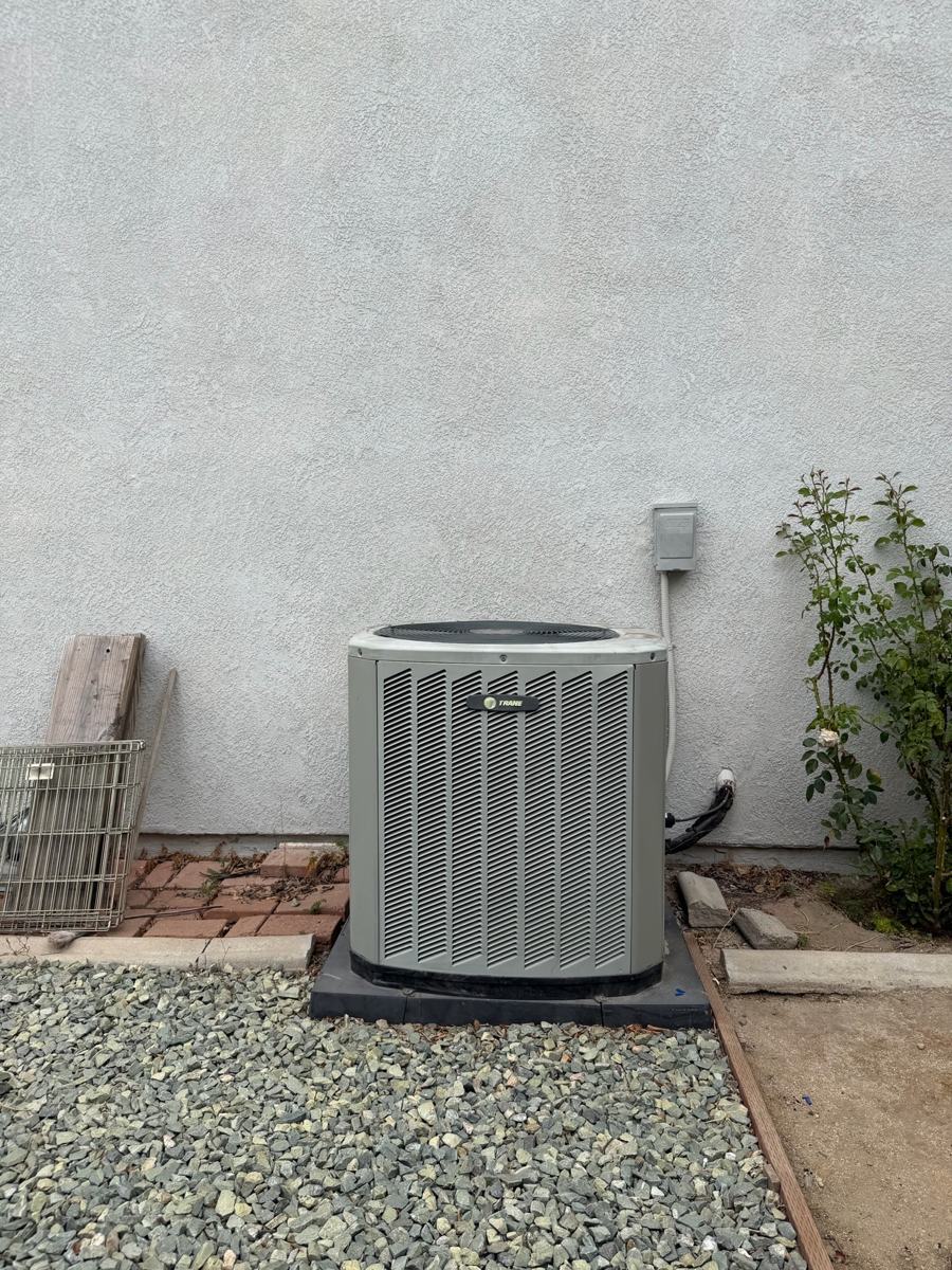 New AC condenser installed on a pad in a side yard