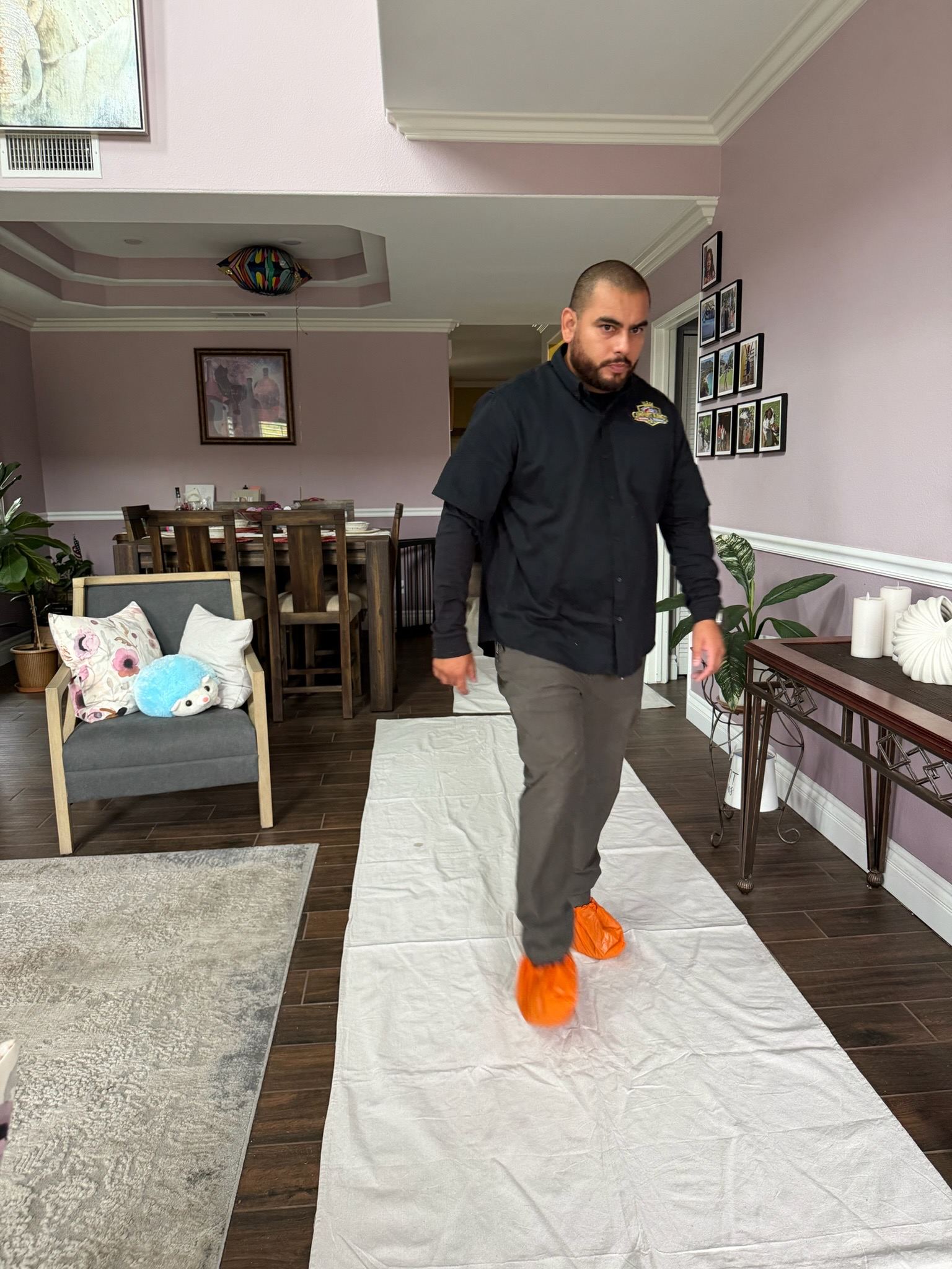 Technician in shoe covers walking on a protective drop cloth inside a home