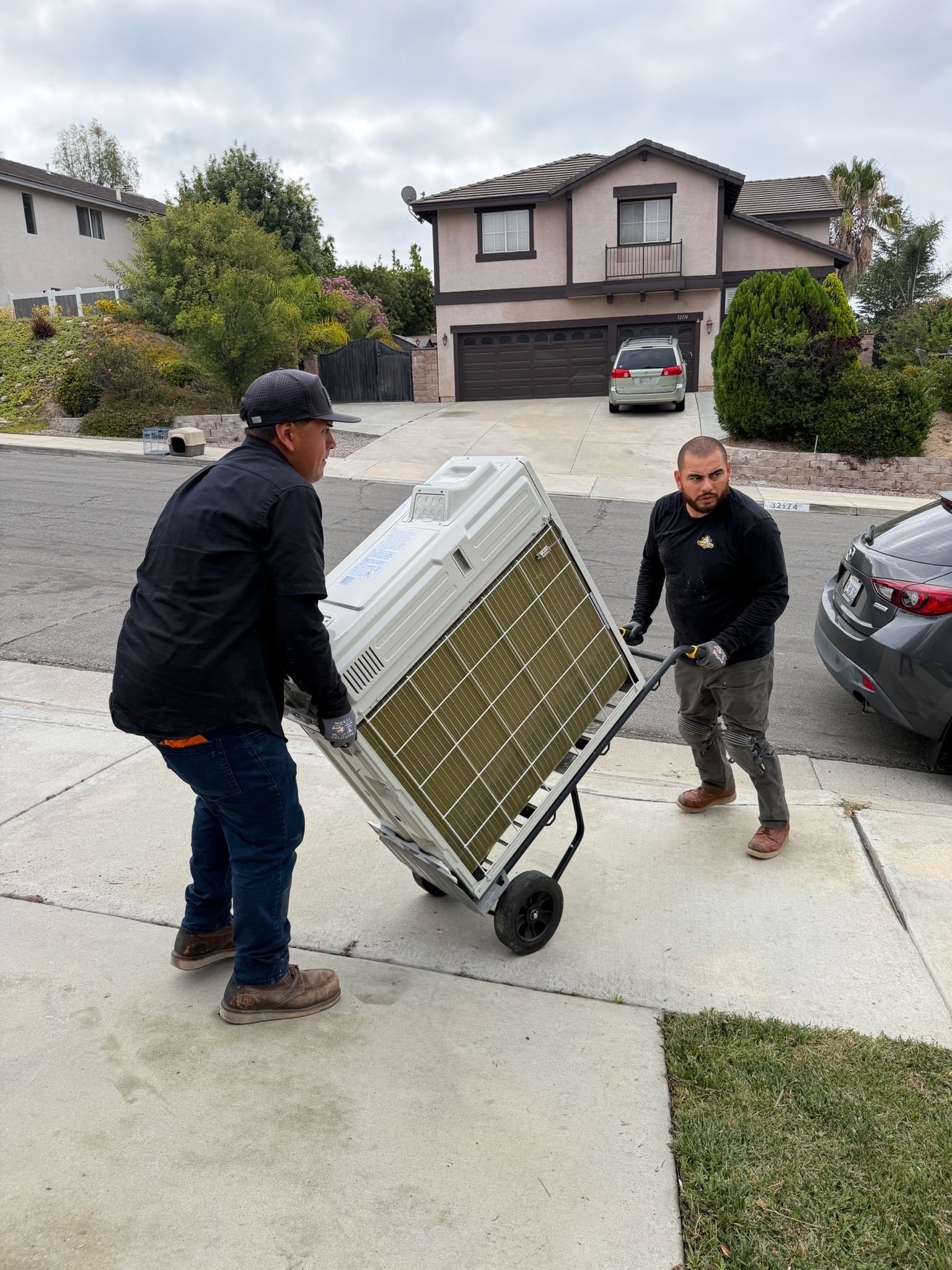 David and Caesar wheeling a new unit up a driveway