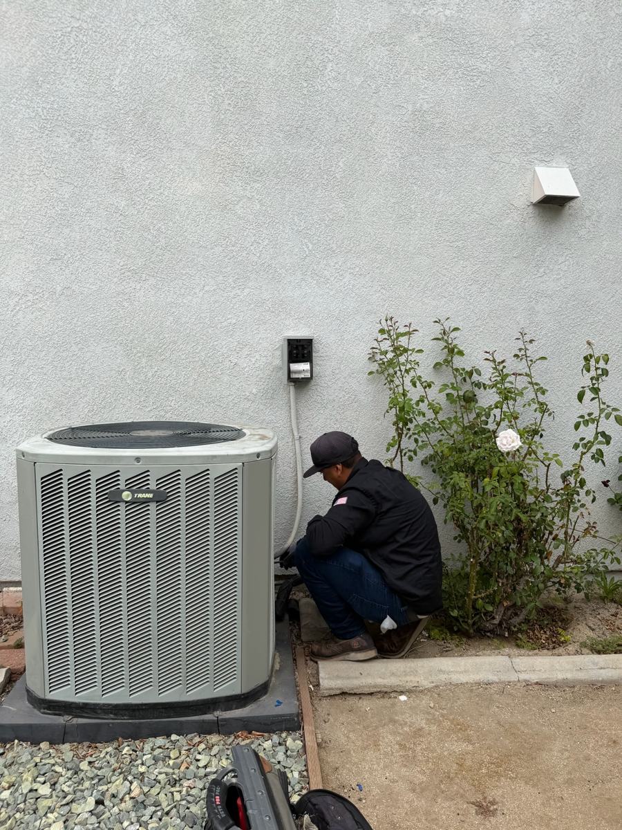 Technician servicing an outdoor condenser