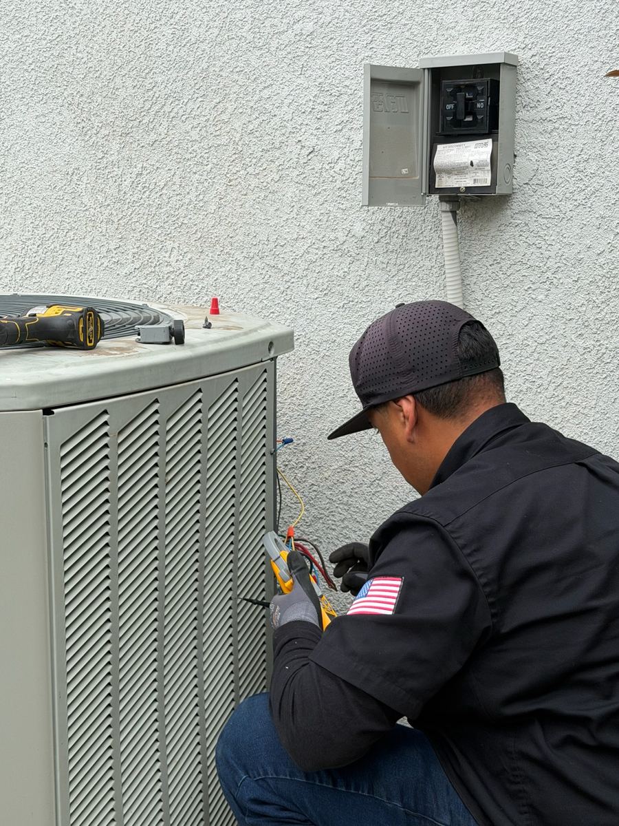 Comfort Kings technician testing the electrical connections on an outdoor AC unit