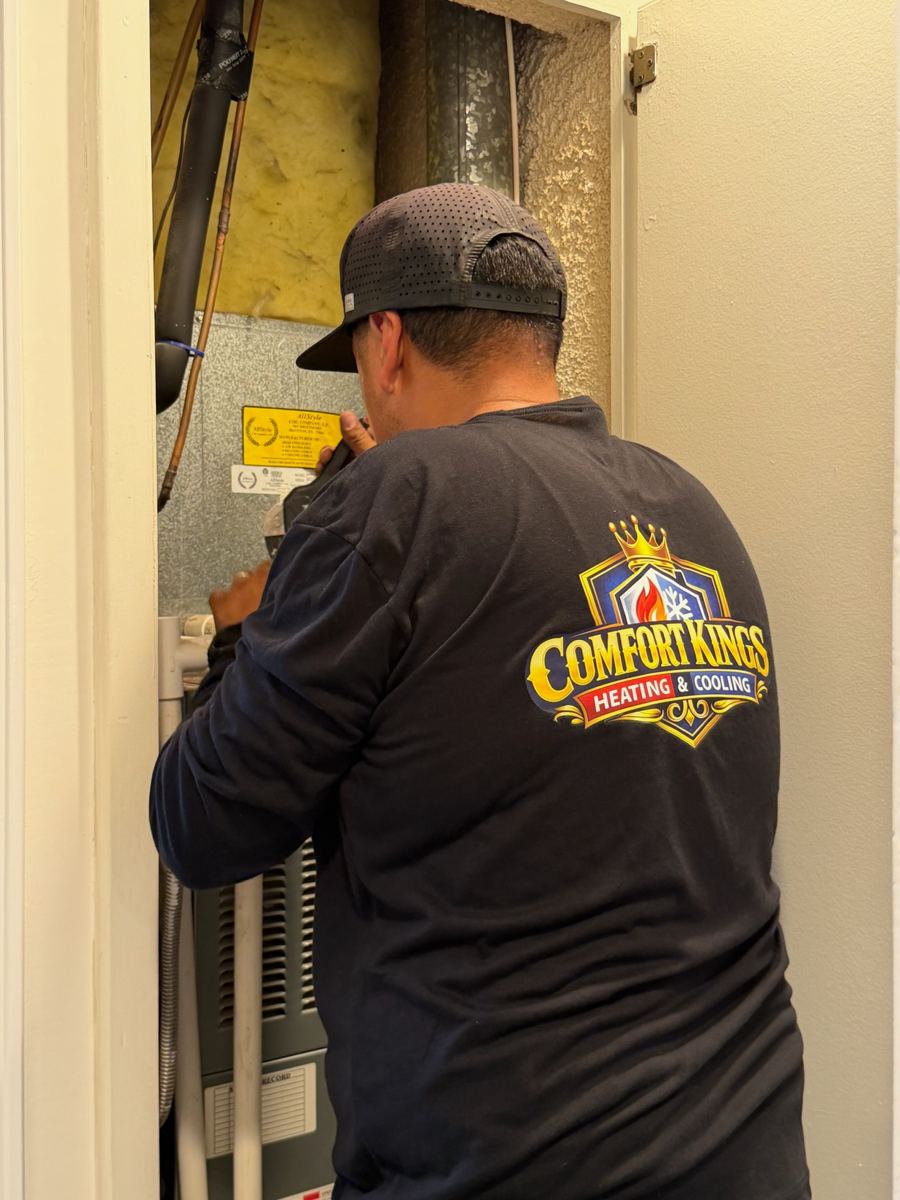 Technician working inside a furnace closet in Poway