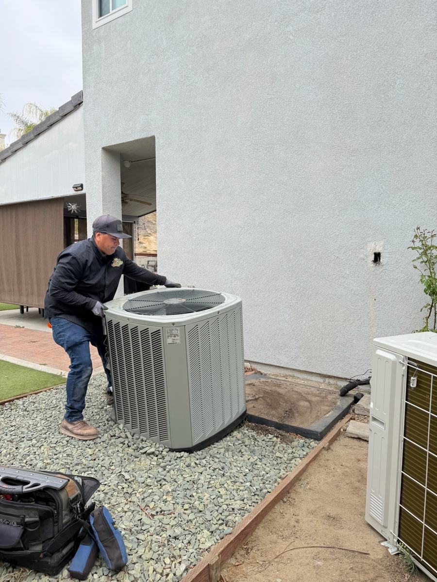 Technician positioning a new condenser